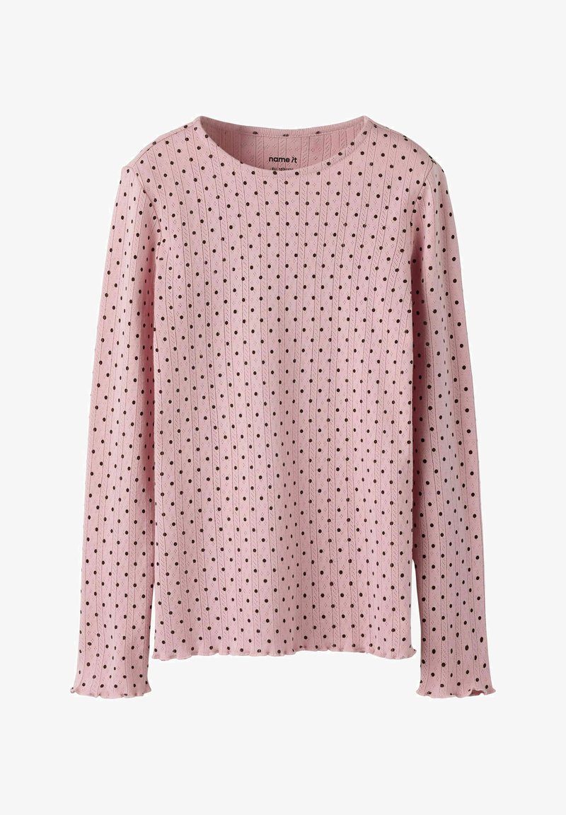 Różowy sweter z długim rękawem o prążkowanej fakturze, ozdobiony wzorem małych czarnych kropek i zaokrąglonym dekoltem. Krawędzie lekko postrzępione.