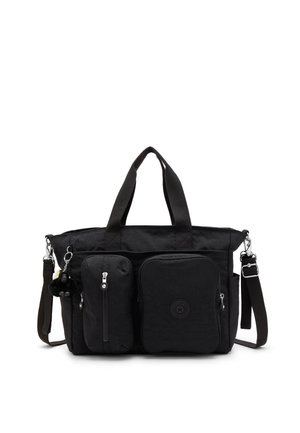 Bolsa tote de tela negra con dos bolsillos frontales con cremallera, asas dobles, una correa de hombro desmontable y un pequeño llavero de peluche en el lado izquierdo.