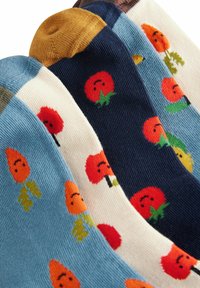 Fire par sokker i forskellige farver: lys blå, mørk blå, creme og brun. Hver har blomsterdesign med smilende røde blomster og grønne blade.