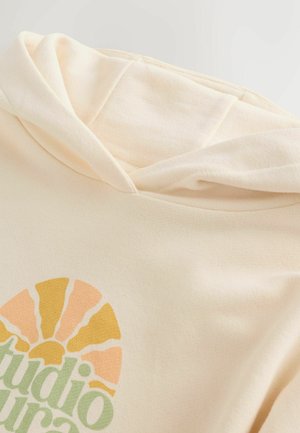 Kremowa bluza z kapturem o miękkiej fakturze, z okrągłą grafiką słońca w kolorach żółtym, pomarańczowym i zielonym. Elegancki ściągacz przy kapturze.