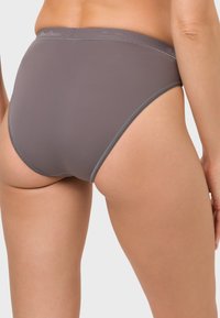 Graue hochgeschnittene Unterwäsche aus glattem Stoff mit einem weichen, elastischen Bund. Detaillierte Nähte entlang der Kanten für einen sauberen Abschluss.