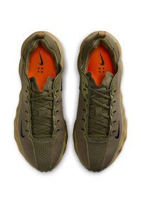 Oliivinvihreät urheilukengät, joissa hengittävä päälliosa, mustia yksityiskohtia, teksturoidut nauhat ja oranssi sisäpohja, jossa on Nike-logo.