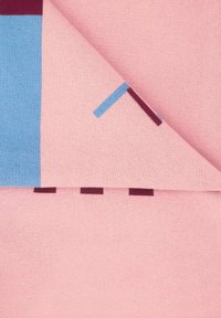 Różowo-niebieski koc bawełniany z geometrycznymi wzorami. Miękka tekstura z gładkim wykończeniem, złożony, aby ujawnić kontrastujące kolory i kształty.