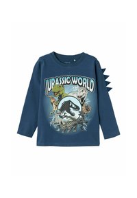 Hosszú ujjú, tengerészszínű pamut póló, amelyen a Jurassic World grafikája látható, különböző dinoszauruszokkal és textúrákkal, valamint tüskékkel díszített ujjakkal.