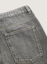 Grå denimjeans med en enda bakficka och kontrasterande sömmar. Texturen är slät med en sliten karaktär.