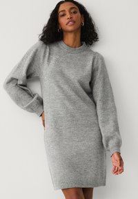 Grå uld sweaterkjole med rund halsudskæring, lange puffede ærmer og ribbede manchetter. Blød tekstur, knælangt design, minimal detaljer.