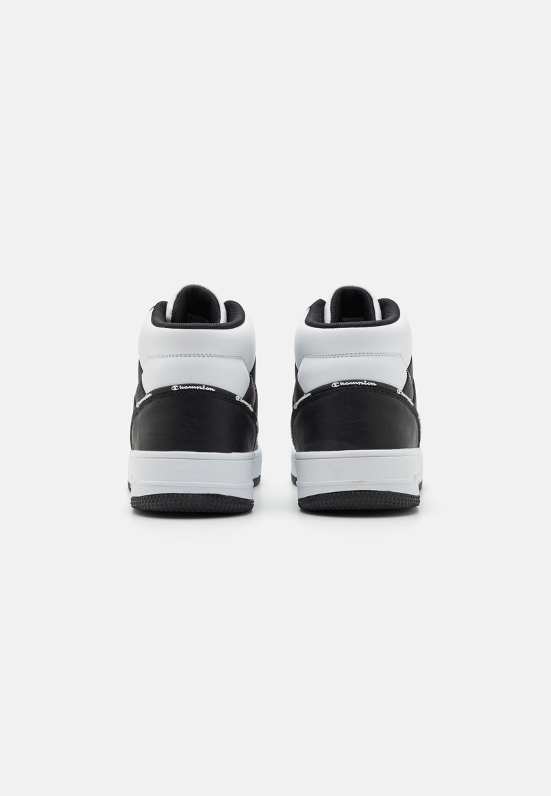 Schwarz-weiße High-Top-Sneaker mit einem glatten Lederdesign, strukturierten Einsätzen und einer Gummisohle mit horizontalen Rillen.