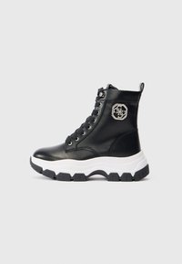 Botine din piele negre, cu vârf înalt, talpă groasă albă, șireturi în față și logo decorative argintiu pe gleznă.