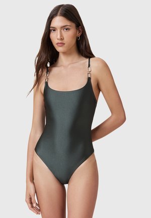 Groene, matte badpak met verstelbare dunne bandjes en zilveren vierkante hardware-details; gladde textuur en hoog uitgesneden benen.