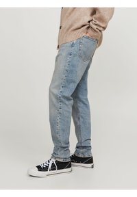 Jeans in denim azzurro chiaro con un design a gamba dritta. Presentano cinque tasche e una classica texture whisker. Abbinati a sneaker nere.