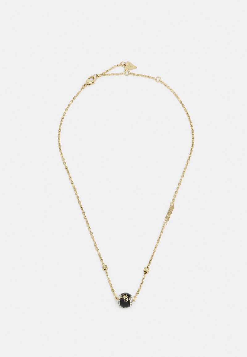 Collar de cadena de oro con una piedra negra central con detalles grabados, acentuado con pequeñas cuentas de oro a lo largo de la cadena.