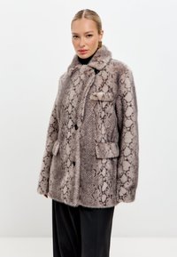 Műszőrme kabát kígyóbőr mintával, bézs és barna árnyalatokban, gallérral, két elülső zsebbel és fekete gombos záródással.