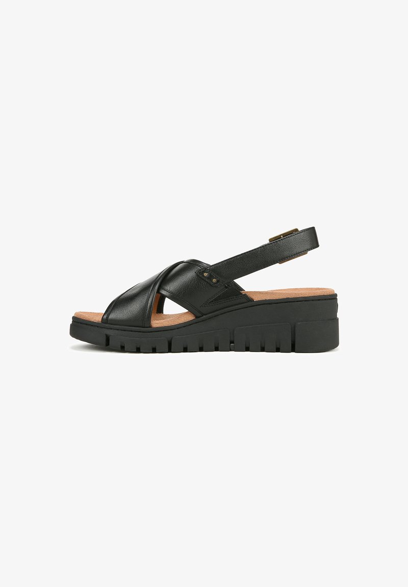 Sandal in pelle nera con design incrociato, soletta in sughero e suola in gomma spessa con scanalature per una migliore aderenza. Include una cinghia regolabile.