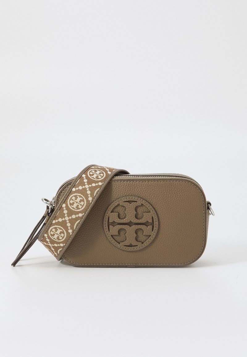 Sac en cuir brun à bandoulière avec un logo circulaire. Doté d'une sangle beige à motif et d'une fermeture éclair. Surface texturée, design compact.