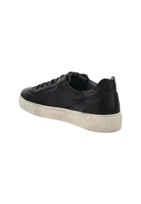 Zwarte laag-top leren sneaker met zwarte veters en een creme-witte rubberen zool, weergegeven vanuit een achteraanzicht op een witte achtergrond.