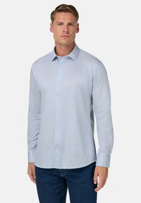 Helles blaues Langarmhemd aus weichem Stoff, mit einer durchgehenden Knopfleiste, klassischem Kragen und sauber verarbeiteten Manschetten.