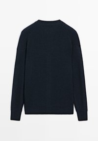 Marinblå ribbstickad tröja med rund halsringning, långa ärmar och texturerade detaljer på axlar och armar. Slät yta med en avslappnad passform.