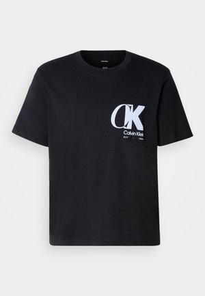 Black cotton t-shirt with short sleeves, round neck, featuring a white "CK" logo on the left chest. Smooth texture, straight hem.