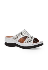 Witte open teen sandaal met bloemmotieven en een bruine zool, met een casual, ademend ontwerp dat geschikt is voor warm weer.