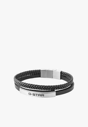 Sort læderarmbånd med flettede og flade remme, sølvspænde og en sølvplade med indgraveret G-STAR brandnavn.