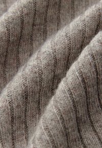 Material tricotat moale, de culoare gri deschis, cu dungi verticale ridicate, având o finisare texturată și nuanțe mai închise subtile distribuite uniform.
