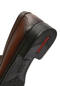 Scarpa in pelle marrone con suola in gomma. Il tacco presenta un accento rosso e una superficie testurizzata. Cuciture visibili lungo il bordo superiore.