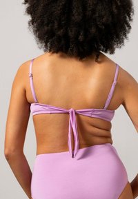 Lila bikini top met verstelbare banden en een strik achterdesign, gecombineerd met bijpassende hoge taille bottom, gemaakt van een soepele stof.