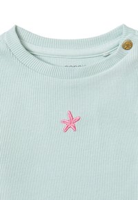 Licht mintgroene geribbelde top met een roze geborduurde zeester en een decoratieve gouden knop op de schouder.