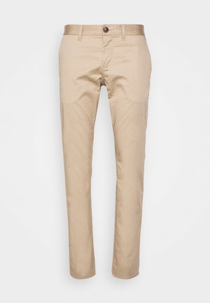 Pantalon décontracté beige ajusté, avec fermeture à bouton, passants pour ceinture et poches latérales, présenté sur un fond blanc uni.