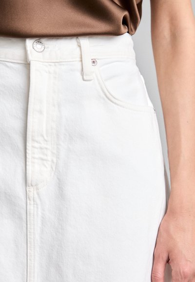 White denim skirt featuring a button closure, contrasting stitching, and side pockets. Fabric has a smooth, matte texture.