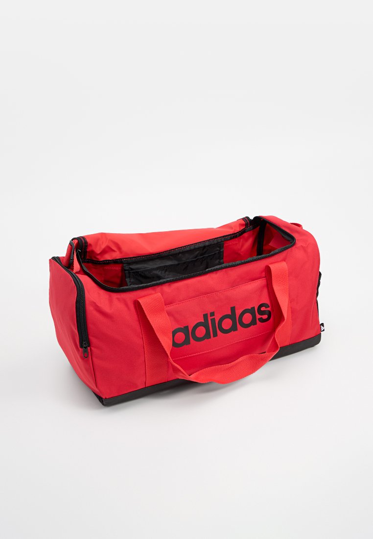 Bolsa de deporte roja hecha de material duradero con detalles en negro. Cuenta con dos asas y un compartimento con cremallera, marcado con un logotipo negro en negrita.