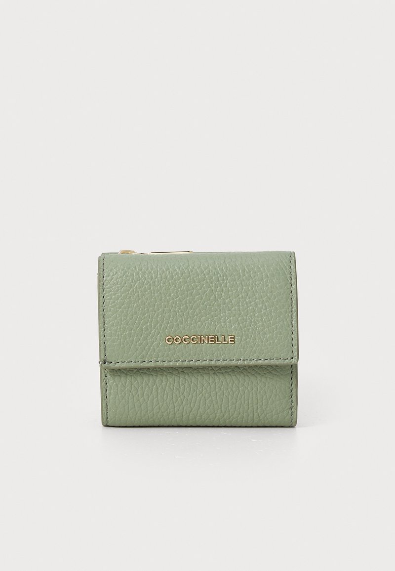 Green textured leather wallet with a fold-over closure and gold "Coccinelle" logo. Compact square shape with neat stitching details.