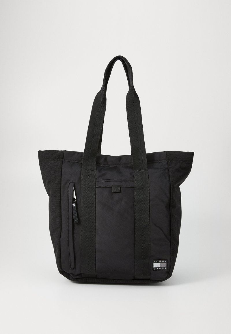 Borsa a tracolla nera con doppi manici in tessuto, tasca laterale con zip, texture morbida e un'etichetta quadrata con logo alla base.