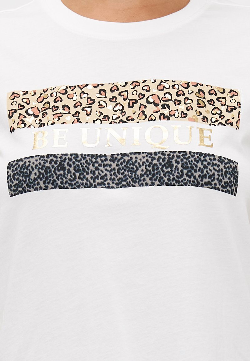 Weißes T-Shirt mit drei horizontalen Streifen: oben im Leopardenmuster mit pinken Akzenten, in der Mitte mit "BE UNIQUE" in Gold, unten im schwarzen Leopardenmuster.