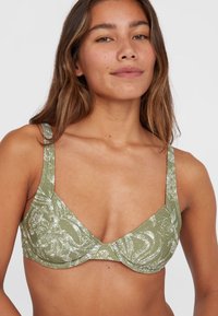 Reggiseno verde a fantasia con scollatura profonda, spalline larghe e tessuto testurizzato che presenta disegni astratti bianchi. Include spalline regolabili.