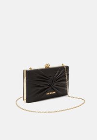 Clutch in faux pelle nera con design annodato, hardware dorato e tracolla a catena, caratterizzato dal logo "Love Moschino" in lettere dorate.