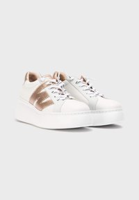 Zapatillas de cuero blanco con detalles en rosa dorado metálico, cordones planos, superposiciones texturizadas y una suela blanca gruesa. Diseño elegante.