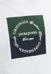 Λευκό βαμβακερό μπλουζάκι με τετράγωνο λογότυπο σε πράσινο και ναυτικό μπλε. Το λογότυπο περιλαμβάνει λευκό κείμενο, όπως "JACK&JONES" και "Est. 1990".