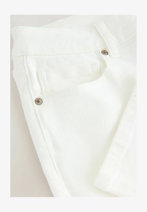 Valge denimkangas, mis näitab lähedalt püksivööd koos nupu ja tikitud tasku detailiga; sile tekstuur ja puhas disain.