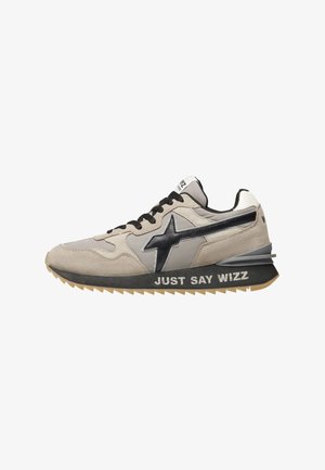 Baskets en daim beige avec des accents noirs, une surface texturée et une semelle en caoutchouc comportant l'inscription "JUST SAY WIZZ" sur le côté.