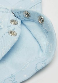 Světlemodrý bavlněný oděv se zapínáním na patentky. Má hladkou texturu a vzor oblaků a slonů tištěný v světlemodré barvě.