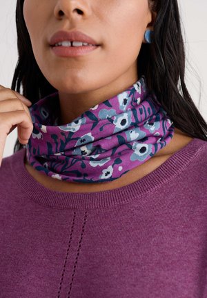 Lillamustriga kaelakate lilla ja sinise toonides, valmistatud pehmest kangast. Kandes ühtlast lilla kampsunit, millel on sooniline kaelus.