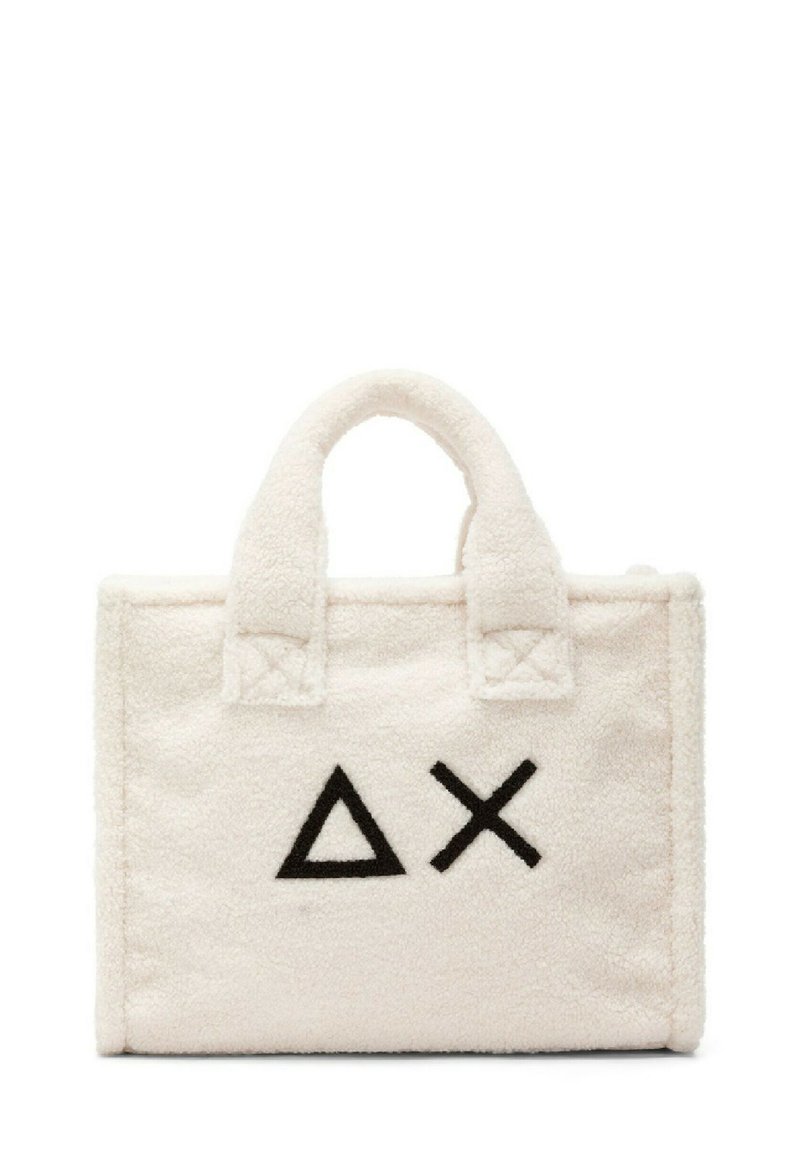 Borsa tote in tessuto bianco e soffice con simboli geometrici neri (triangolo e X) sul fronte; dotata di manici corti e robusti.