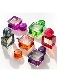 Seks fargerike KIKO parfymeflasker: lilla, grønn, oransje, rosa, grå, med firkantede og runde former, glatte overflater og metalliske detaljer.