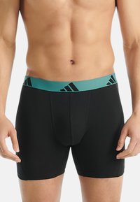Zwarte boxerbriefs met een teal elastische tailleband met zwarte Adidas logo-accenten. Glad materiaal, aansluitend ontwerp, knielange snit.