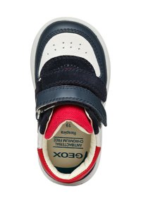 Sneaker per bambini Geox; tomaia in pelle e suede blu, puntale bianco, dettagli rossi e blu, strap in velcro e design perforato per la traspirabilità.