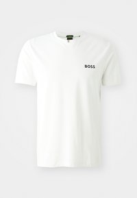 Valge lühikeste varrukatega T-särk, mis on valmistatud puuvillast, ümmarguse kaelusega ja musta "BOSS" logoga vasakul rinnal. Sile tekstuur.