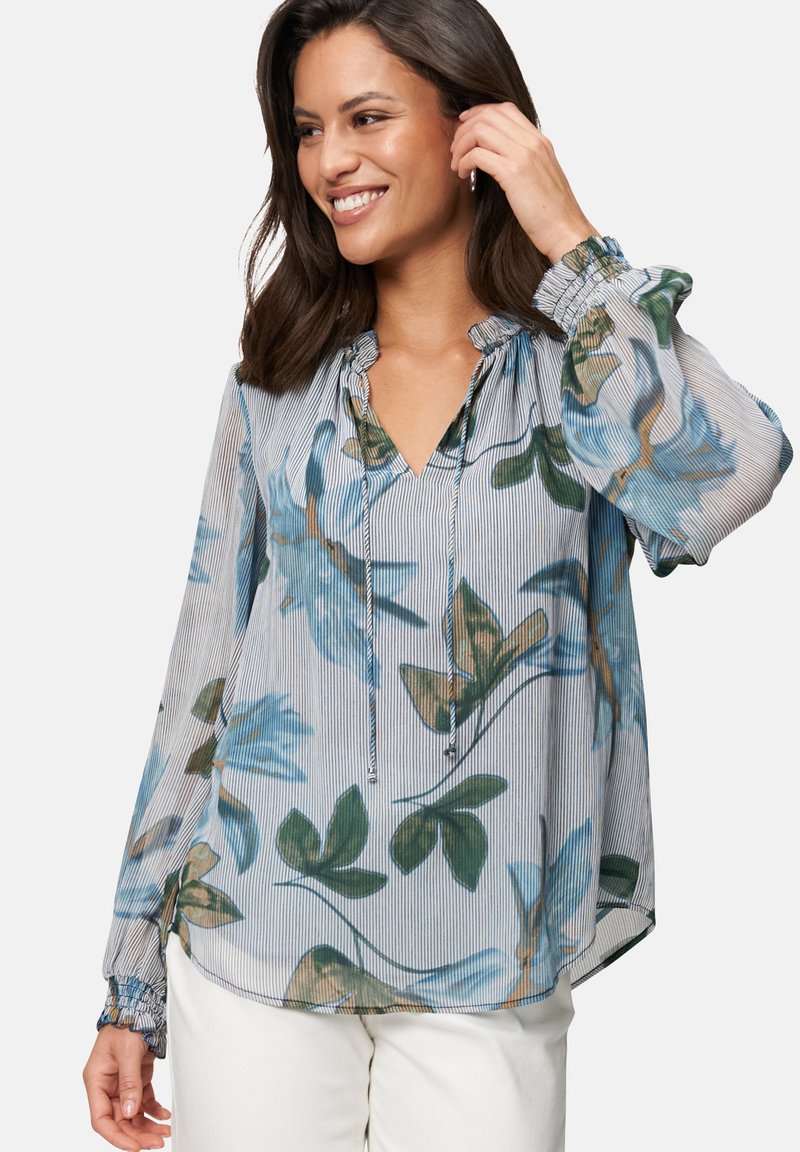 Floral-patterned blouse in light blue with green accents. Features a V-neck, gathered neckline, and elasticized cuffs. Lightweight fabric.