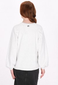 Felpa leggera grigia con maniche raglan, scollatura a costine e dettaglio sulle spalle arricciato. Presenta un piccolo logo sul retro.