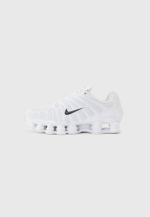 Valkoinen Nike-juoksukenkä mustalla swoosh-logolla, verkkopäällisellä ja joustavan segmentoidulla pohjallaan, joka on suunniteltu vaimennukseen ja tukeen.